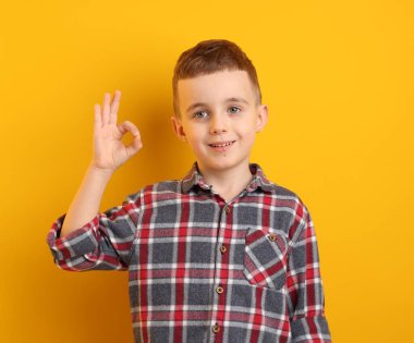 Mutlu çocuk sarı arka planda iyi bir hareket gösteriyor.