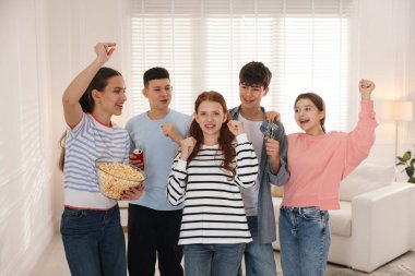 Evde dart oynayan bir grup genç.