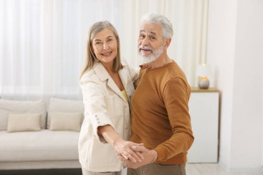 Güzel yaşlı çift evde dans ediyor.