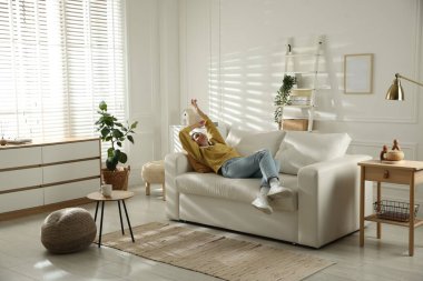 Mutlu kadın evdeki kanepede dinleniyor.