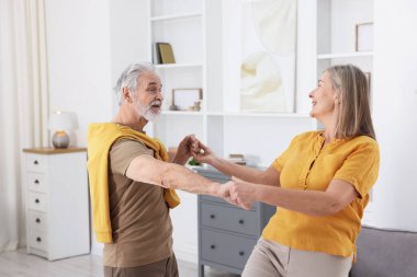 Güzel yaşlı çift evde dans ediyor.