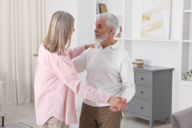 Güzel yaşlı çift evde dans ediyor.