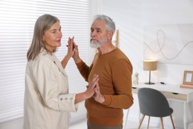 Güzel yaşlı çift evde dans ediyor.