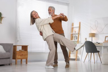 Güzel yaşlı çift evde dans ediyor.