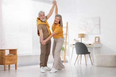 Güzel yaşlı çift evde dans ediyor.