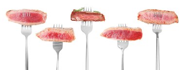 Izgara biftek parçaları beyaz arka plana karşı çatallar, set