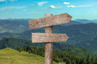 Dağların farklı yönlerini gösteren okları olan tahta tabela direği.