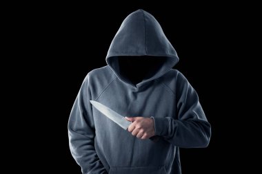 Kapüşonlu kimliği belirsiz bir suçlu siyah arka planda bıçak tutuyor.