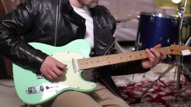 Stüdyoda elektro gitar çalan adam, yakın plan.