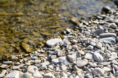 Güneşli bir günde taşlı ve çakıl taşlı nehir kıyıları
