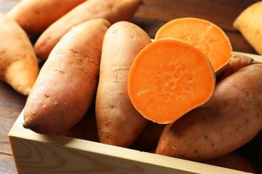 Tahta masadaki sandıkta çiğ patates, yakın plan.