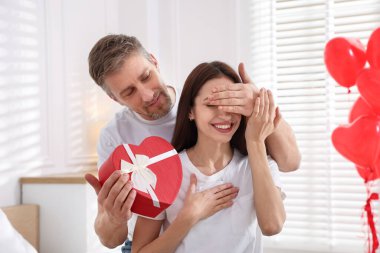 Sevgililer günü hediyesiyle sevgilisine sürpriz yapan mutlu bir adam.