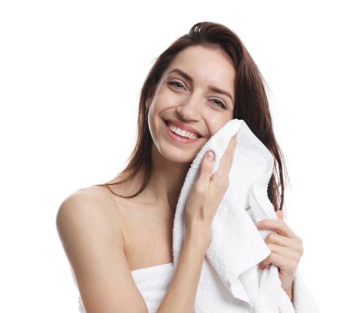 Güzel bir kadın beyaz arka planda havluyla saçlarını kurutuyor.