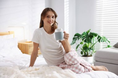Evde yatağında bir fincan aromatik kahveyle güzel bir kadın. Metin için boşluk