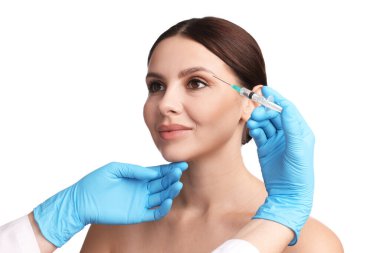 Estetik ameliyat. Doktor beyaz arka plandaki hastaya yüz enjeksiyonu yapıyor.