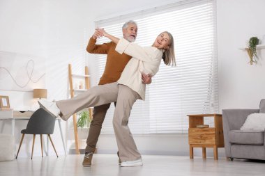 Güzel yaşlı çift evde dans ediyor.