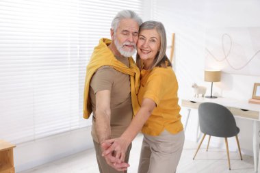 Güzel yaşlı çift evde dans ediyor.