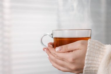 Bir fincan çay tutan kadın, yakın plan. Metin için boşluk