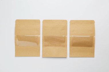 Hafif arka planda üç Kraft stand-up kesesi, düz yatıyordu.