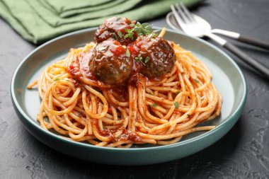 Köfteli lezzetli makarna siyah desenli masada servis ediliyor, yakın plan.