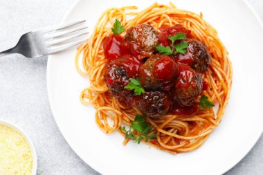 Açık gri masada servis edilen köfteli leziz makarna.