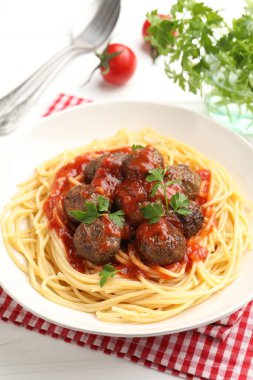 Köfteli lezzetli makarna beyaz ahşap masada servis ediliyor, yakın plan.