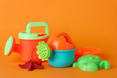 Parlak çocuk plaj oyuncakları ve turuncu arka planda denizyıldızı