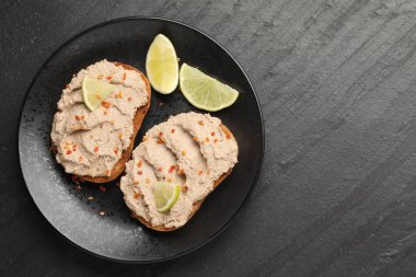 Lezzetli bruschettalar, ezmeli, limonlu ve baharatlı, koyu dokulu masa, üst manzara. Metin için boşluk