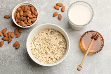 Yulaf gevreği, badem sütü, fındık ve bal gri masada, düz yatıyordu.