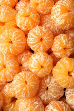 Arka plan olarak birçok olgun soyulmuş mandalina, üst görünüm