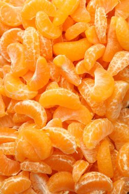 Arka plan olarak birçok olgun soyulmuş mandalina, üst görünüm