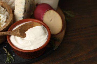 Farklı süt ürünleri ve biberiye ahşap masada, yakın plan. Metin için boşluk