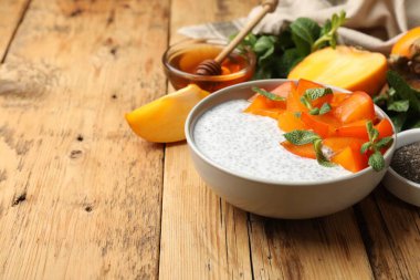 Hurmalı Chia pudingi ve ahşap masada servis edilen nane şekeri. Metin için boşluk