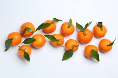 Taze, sulu mandalinalar ve beyaz arka planda yeşil yapraklar.