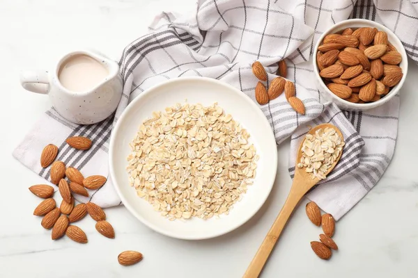 Yulaf gevreği, badem sütü ve fındıklar beyaz mermer masada, düz yatıyordu.