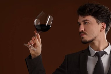 Kahverengi arka planda şarap kadehleri olan profesyonel şarap garsonu.