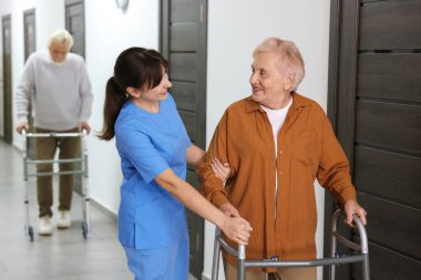 Huzurevinde Walker 'a yardım eden bakım işçisi.