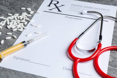 Boş alanlar, steteskop, haplar ve şırınga içeren tıbbi reçete formu, kapalı dokuma masası