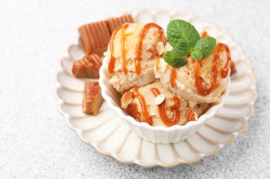 Karamel soslu lezzetli dondurma, badem ve nane şekeri, yakın plan.