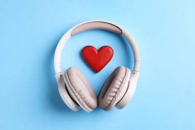 Açık mavi arka planda kulaklık ve kalp figürü, üst görünüm