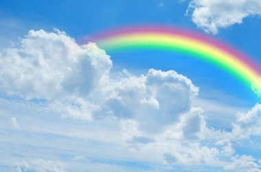 Parlak renkli gökkuşağı ve mavi gökyüzündeki bulutlar