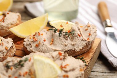 Lezzetli bruschettalar, ezme, limon dilimleri, kekik ve kurutulmuş havuç taneleri ahşap masada, yakın plan.