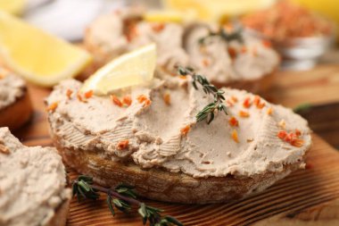 Lezzetli bruschettalar, ezme, limon dilimleri, kekik ve kurutulmuş havuç taneleri ahşap masada, yakın plan.