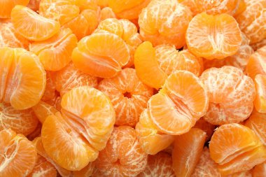 Arka plan olarak birçok olgun soyulmuş mandalina, üst görünüm