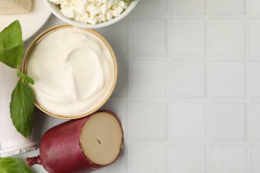 Farklı süt ürünleri ve fesleğen beyaz fayanslı masa, düz yatak. Metin için boşluk