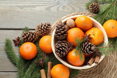 Olgun mandalinalar, baharatlar, koniler, cevizler ve köknar ağacı dalları ahşap masa üzerinde, düz yatıyordu.