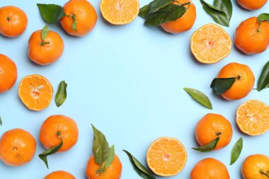 Taze mandalina ve açık mavi arka planda yeşil yapraklar, düz. Metin için boşluk
