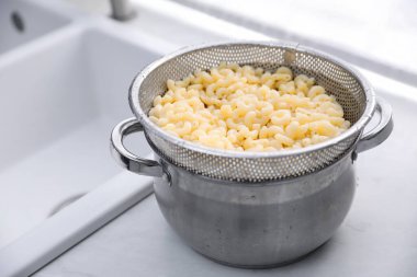 Mutfakta elek ve makarna, yakın plan.