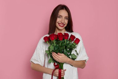 Sevgililer Günü. Pembe arka planda gülleri olan kadın