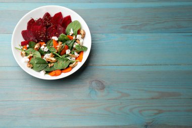 Pancar salatası, ıspanak, peynir, ceviz ve havuç, mavi ahşap masa, üst manzara. Metin için boşluk